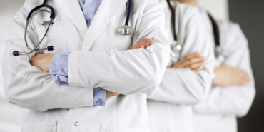 Group,Of,Modern,Doctors,Standing,As,A,Team,With,Arms